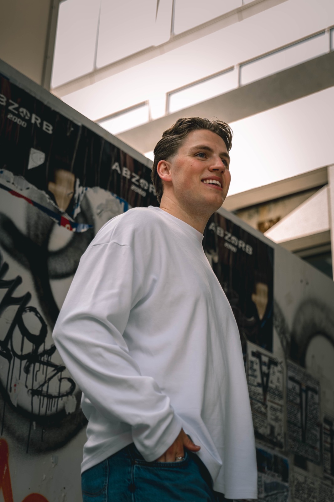 ELAIH lachend bij een graffitimuur