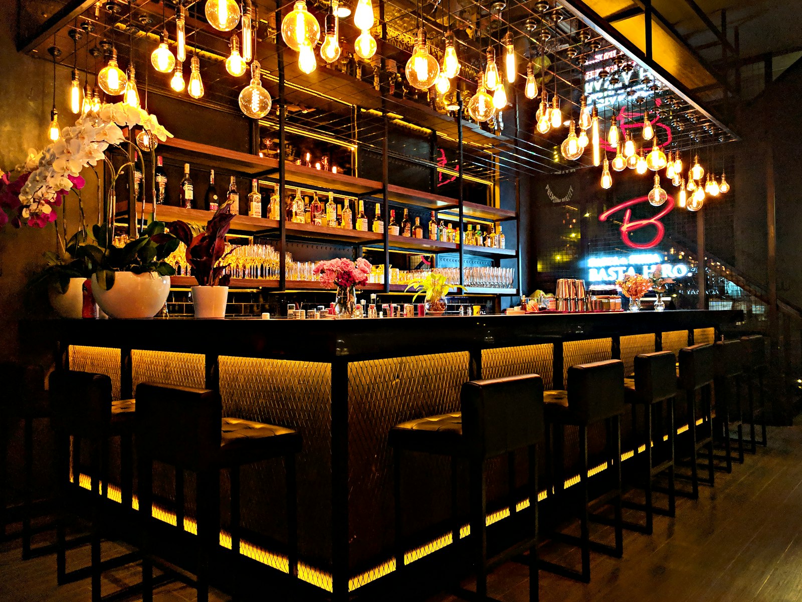 Cocktailbar met warme verlichting en gevulde schappen